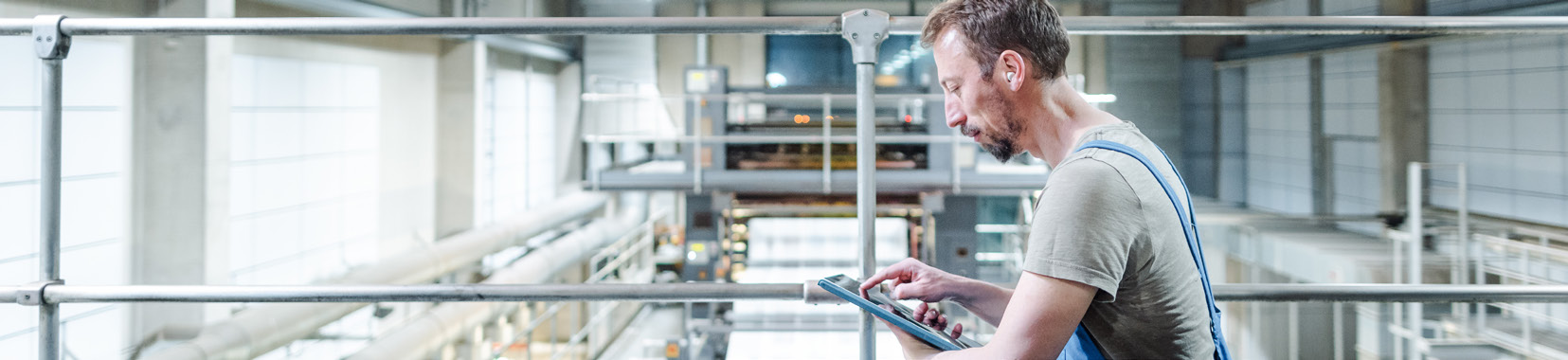 Manufacturing facility interior with worker using a tablet device