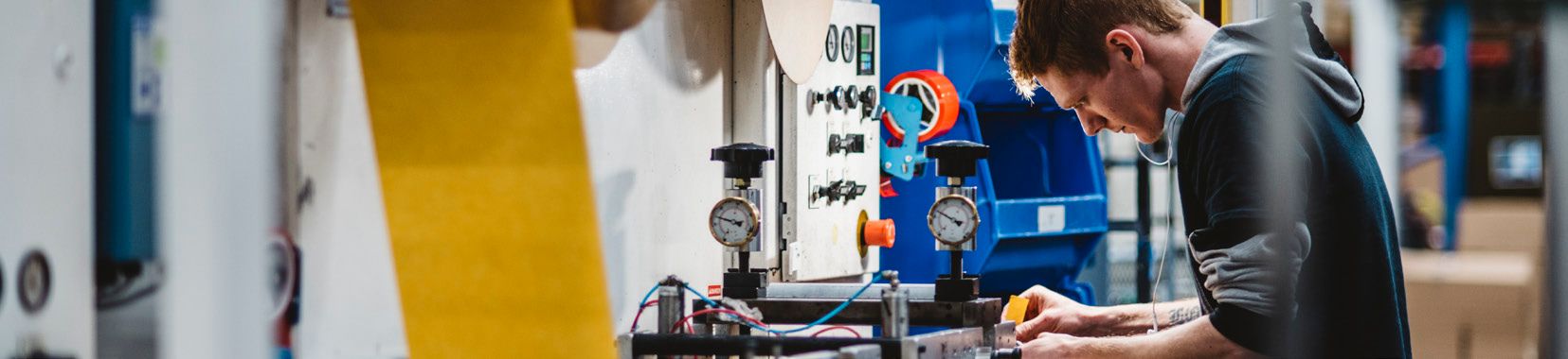 manufacturing facility interior photo with worker operating equipment