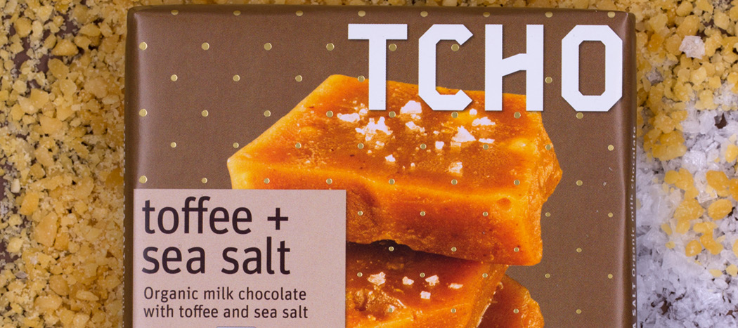 close-up photo of toffee and sea salt chocolate bar with TCHO logo in background