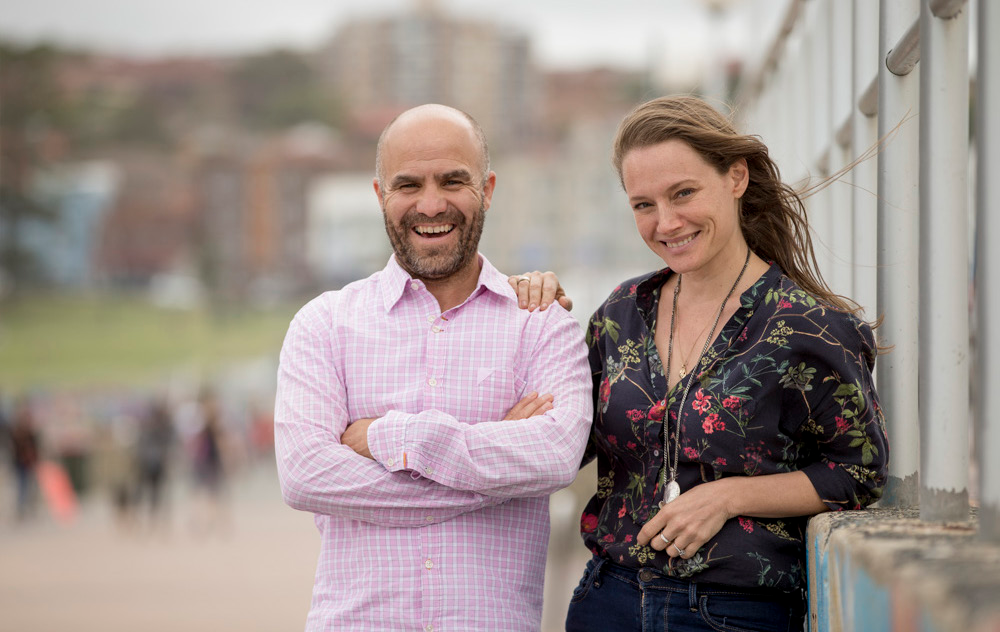 Photo of Ethan Nyholm and Adina Jacobs standing outdoors, casual attire, blurred background
