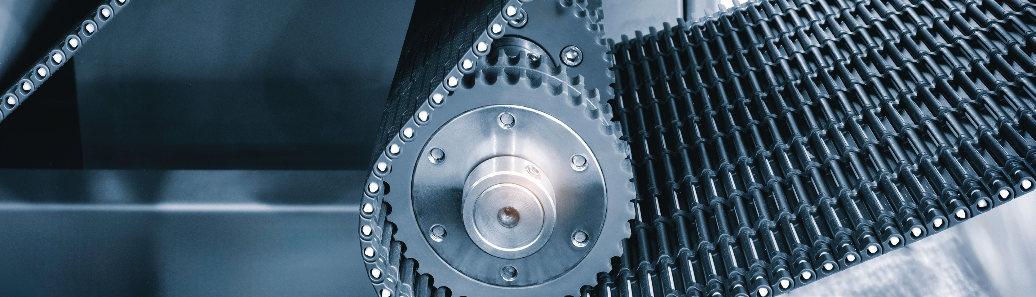 close-up photo of a steel detachable chain and sprocket mechanism in a manufacturing setting