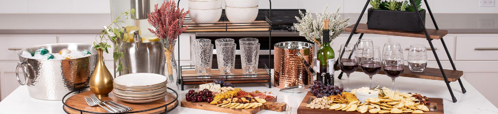 table set with wine glasses, plates, cutlery, and decorative plants on a white kitchen counter