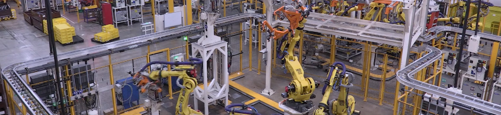 Manufacturing facility interior with robotic arms and assembly line equipment