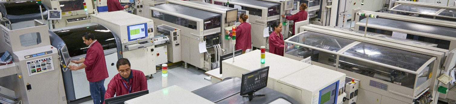 Workers operating production line in a brightly lit manufacturing facility