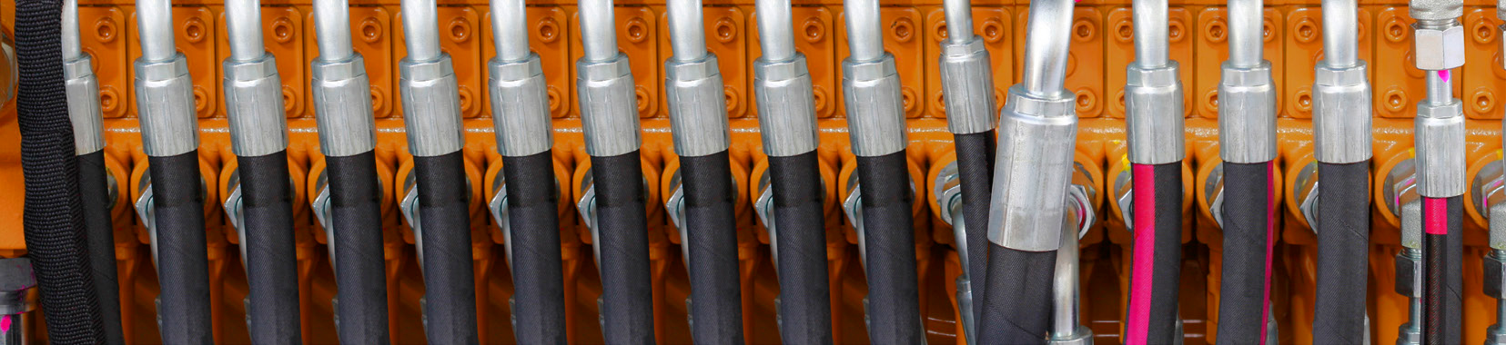 close-up photo of industrial fluid routing system components with orange background
