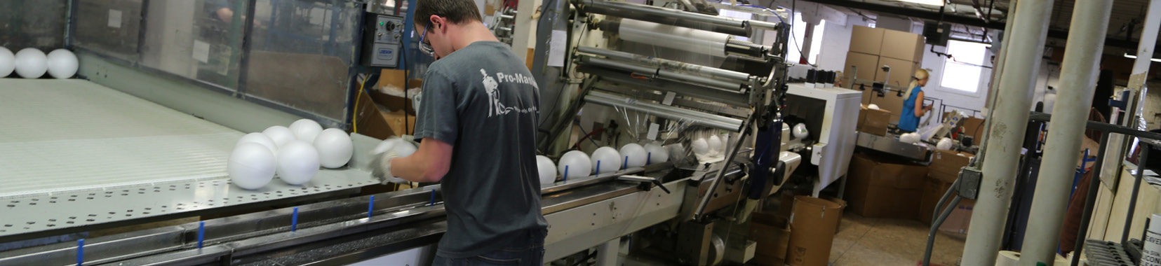 Workers operating production line in a brightly lit manufacturing facility