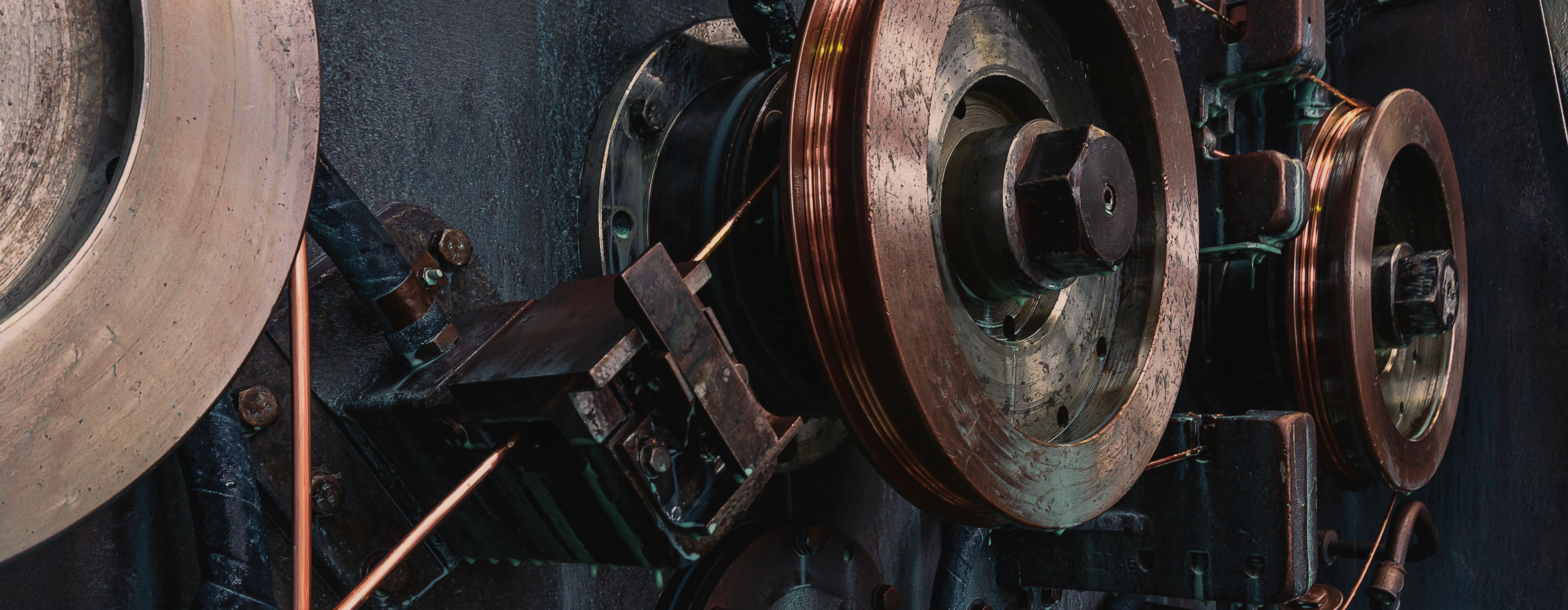 close-up photo of industrial machinery with large metal pulleys and mechanical components