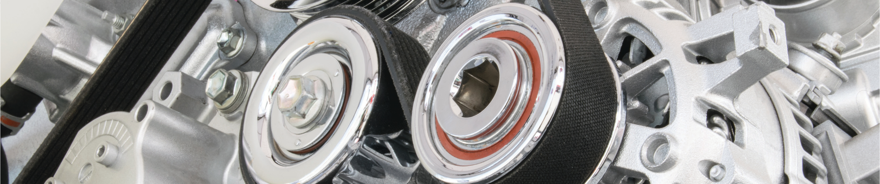 close-up photo of industrial machine pulleys and belts in a manufacturing setting