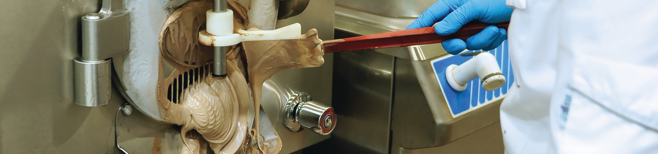 operator working on chocolate production equipment in a manufacturing facility