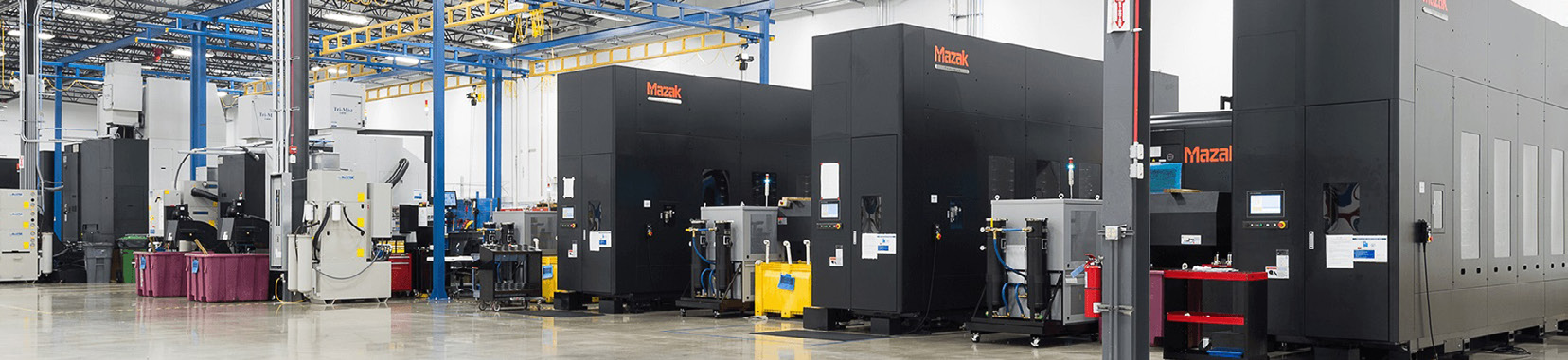 manufacturing facility interior photo with large black industrial machines and bright overhead lighting