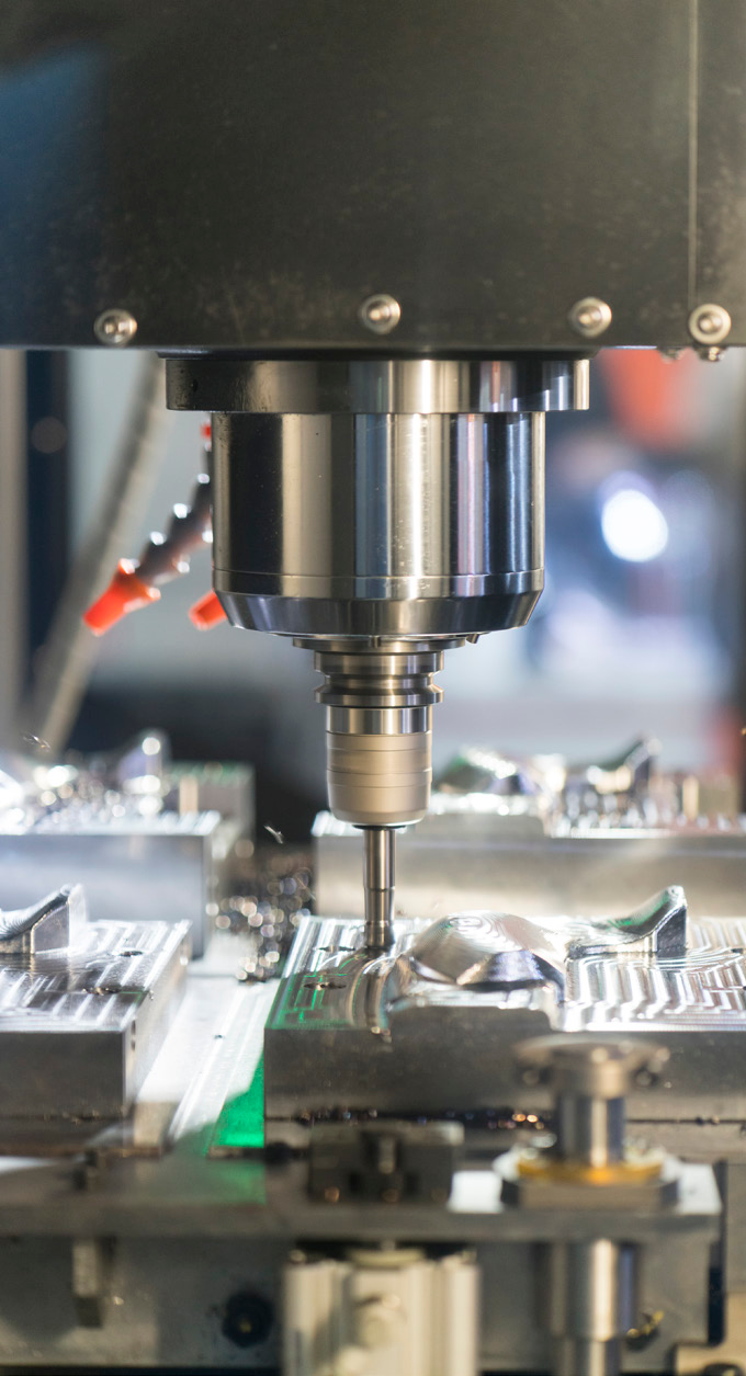 close-up photo of a metal machining process with drill and metal parts in a manufacturing facility