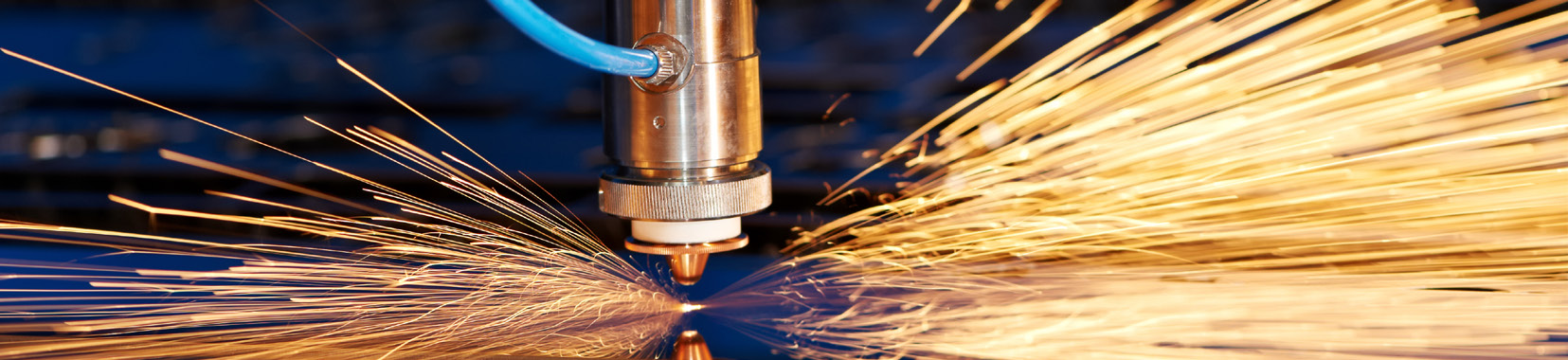 close-up photo of sparks flying from a metal cutting or grinding machine in a manufacturing facility