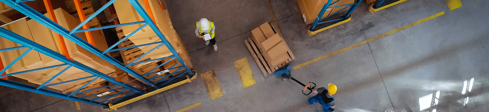 Overhead view of workers and pallets in a warehouse with yellow and blue racks