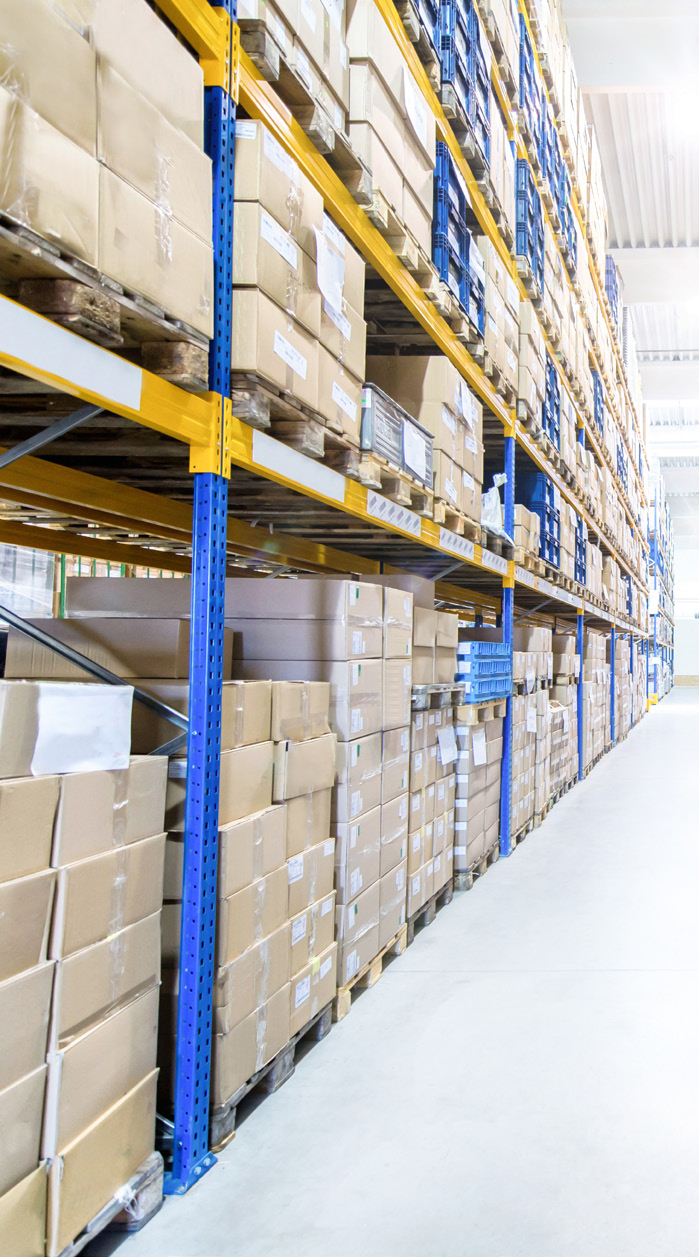 warehouse interior with stacked boxes on metal shelving racks, bright lighting