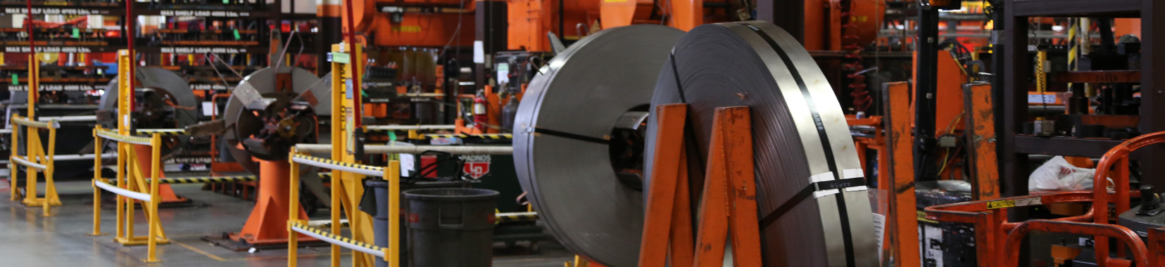 manufacturing facility interior with large metal coils and industrial equipment