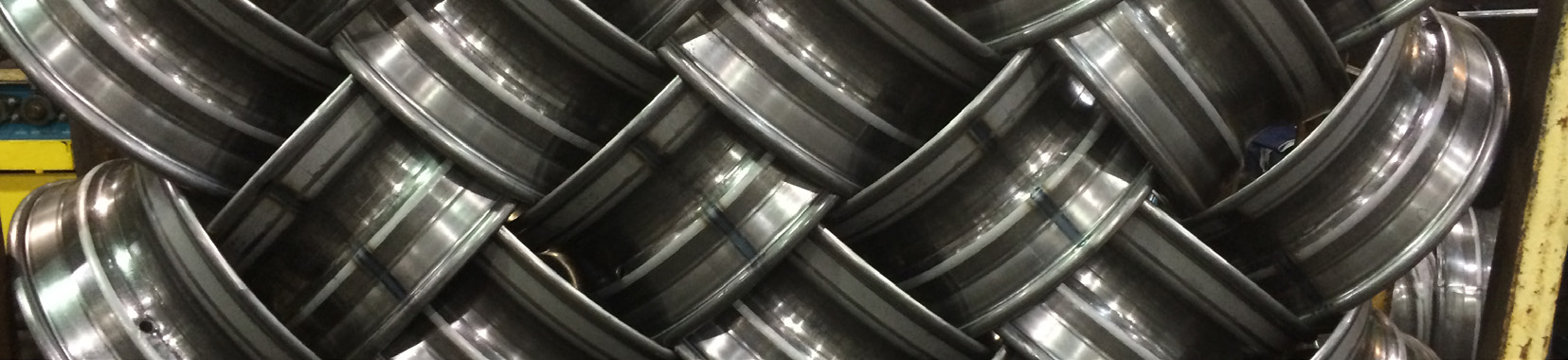 close-up photo of shiny metal wheels stacked in a factory setting
