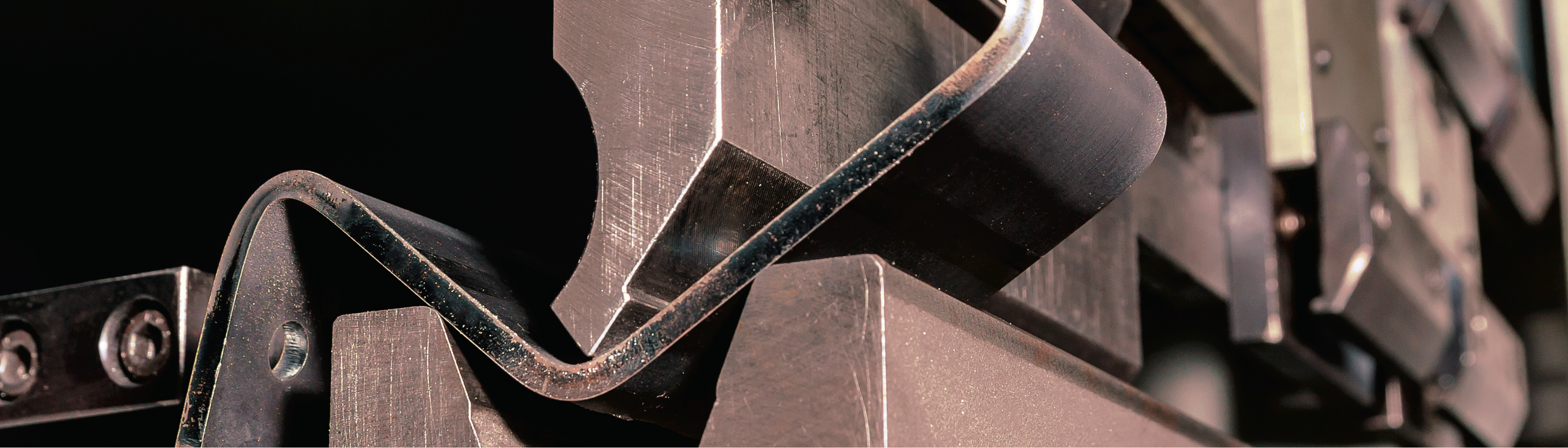 close-up photo of metal manufacturing equipment with dark background