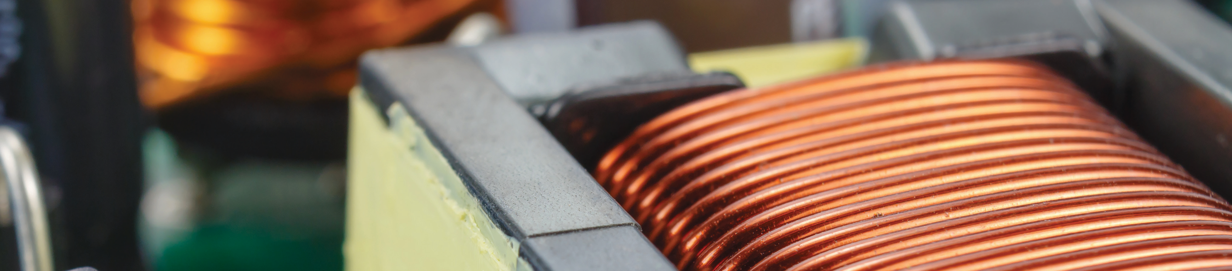 close-up photo of copper coil and electrical components in manufacturing setting