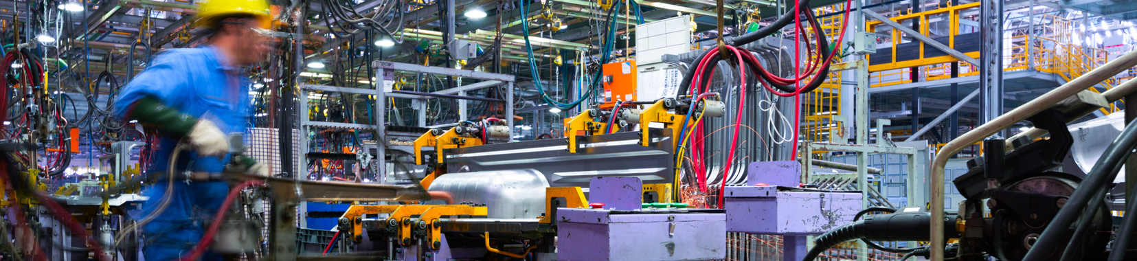 manufacturing facility interior with workers and machinery in motion