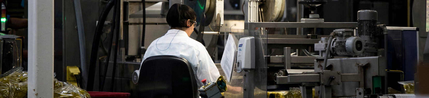 manufacturing facility interior with worker operating production line