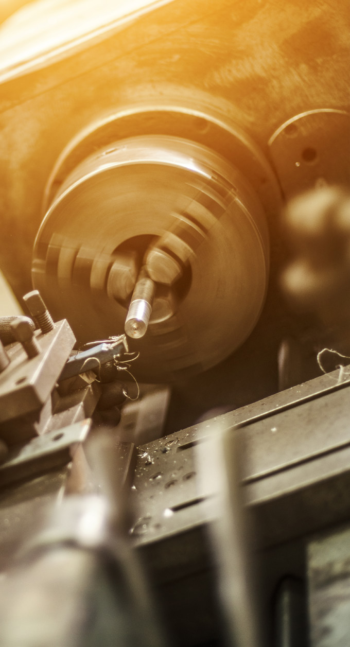 close-up photo of industrial stamping machine with warm orange lighting