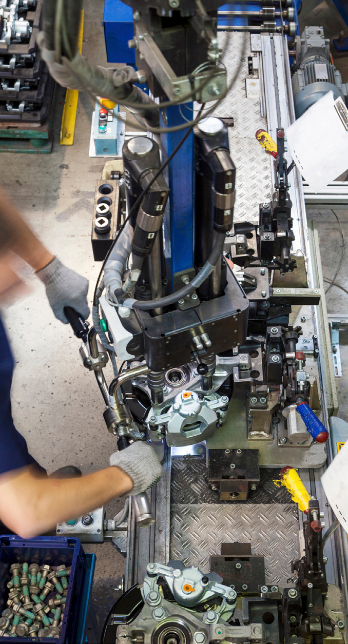 manufacturing facility interior with worker operating machinery and robotic arms