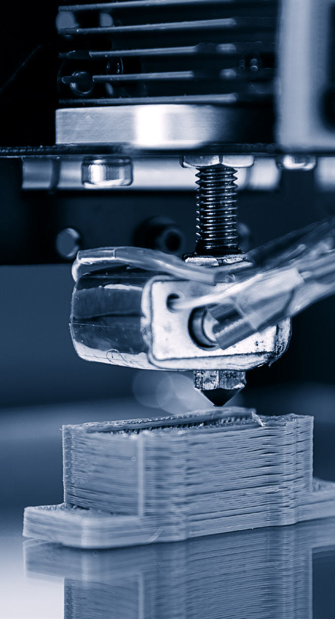 close-up photo of a metal clamp and coil in a manufacturing setting with blue lighting