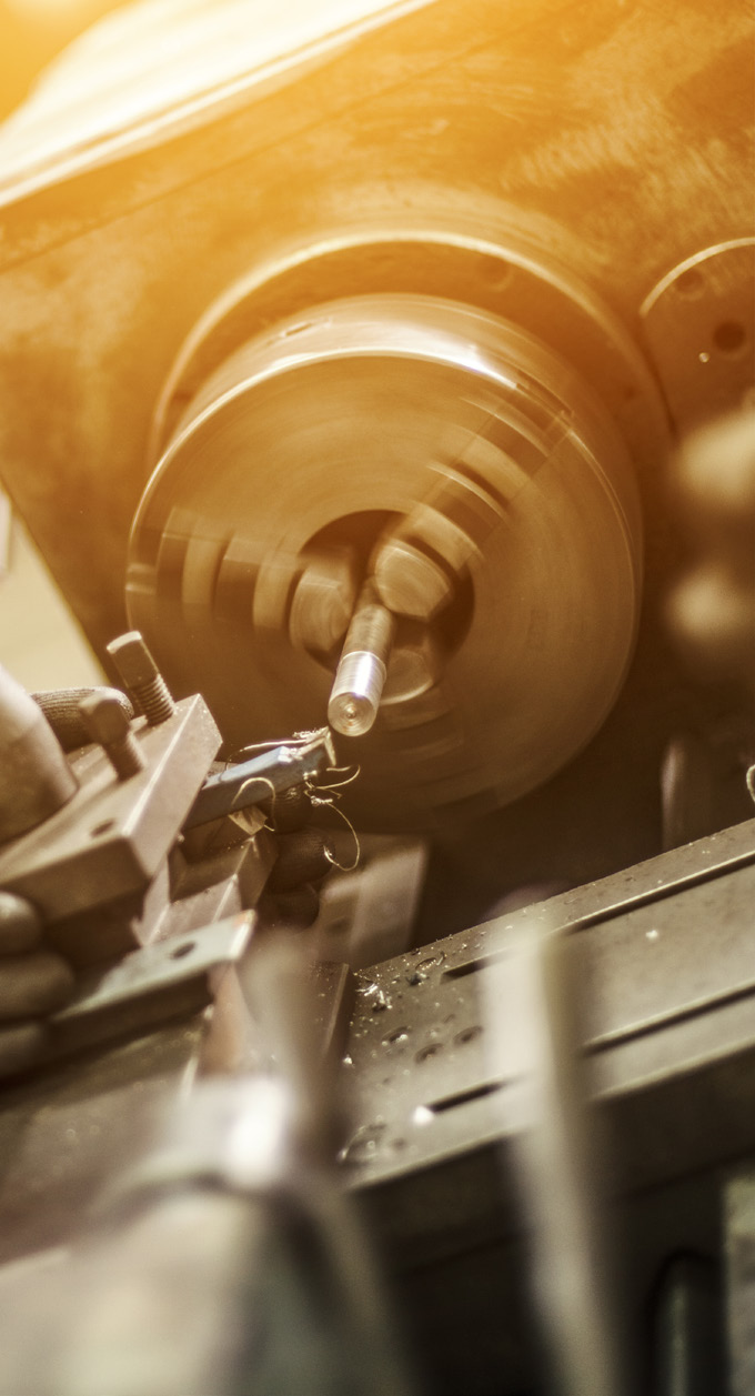 Close-up photo of a metalworking lathe machine in operation with metal shavings