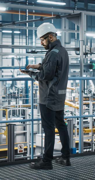 manufacturing facility interior with worker operating equipment, predominantly blue and gray tones