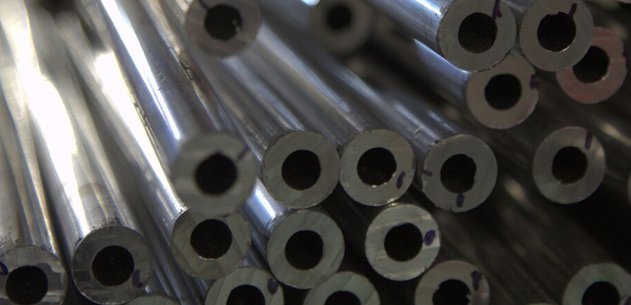 close-up photo of stacked metal pipes with hollow centers in a factory setting