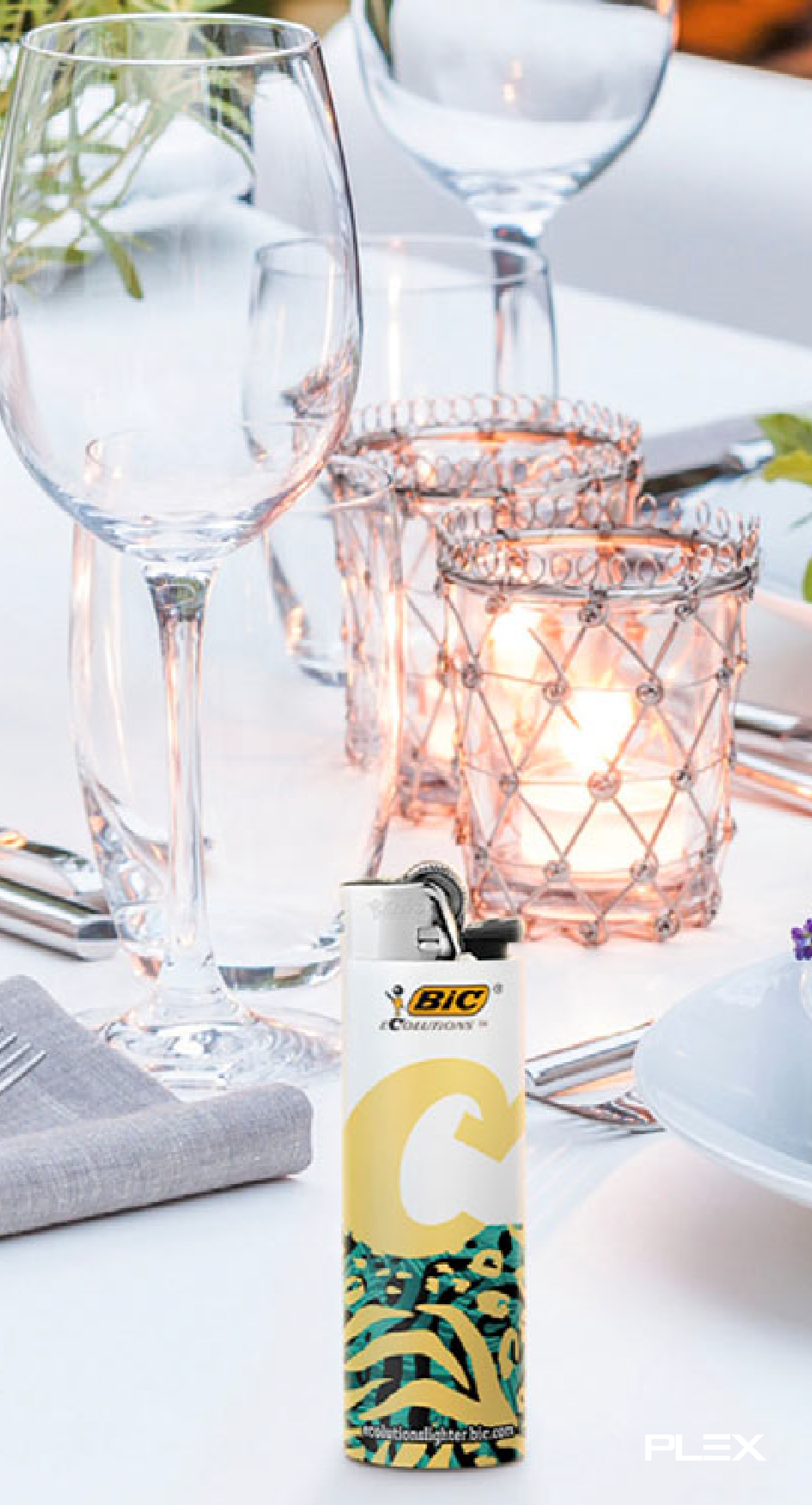 BIC branded lighter on a table with glassware in the background