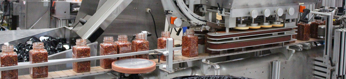 production line with spice bottles in a manufacturing facility