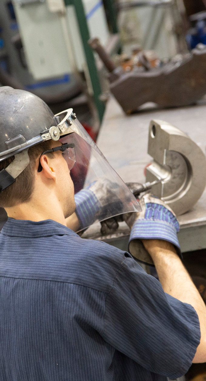 Worker operating metal forming equipment in a manufacturing facility