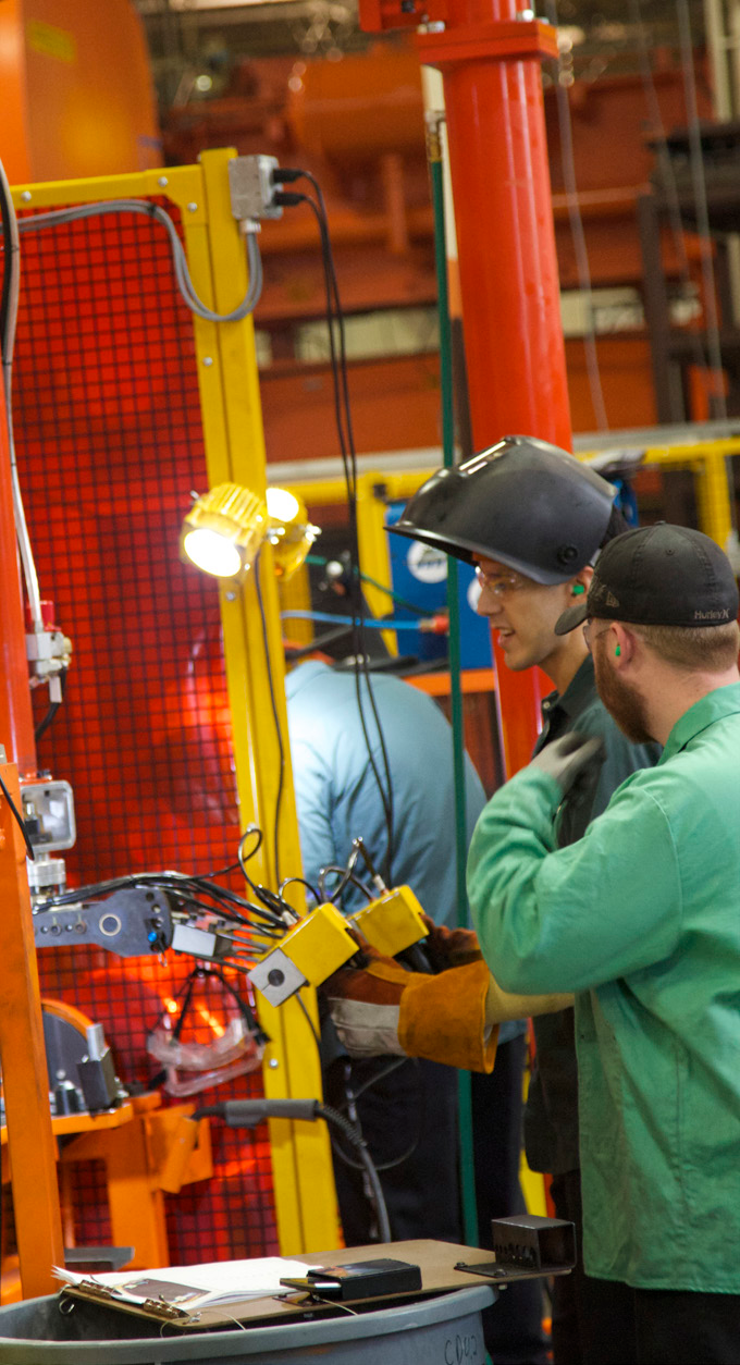 Workers operating production line in a brightly lit manufacturing facility