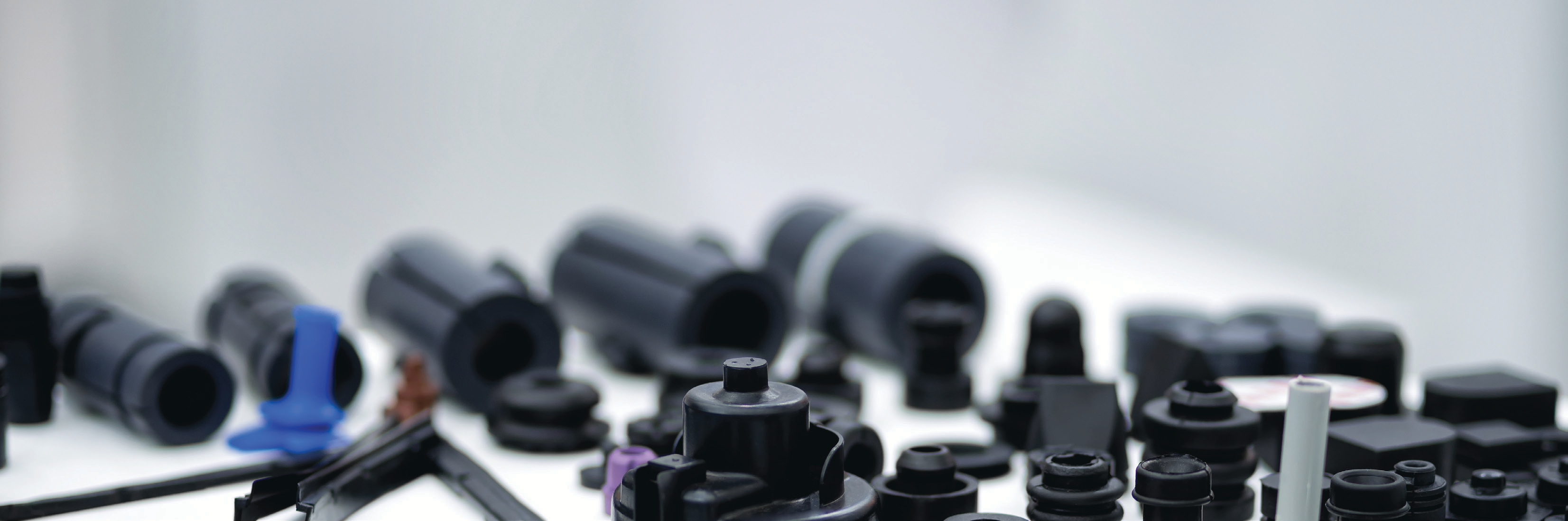 blurred close-up photo of black cylindrical machine parts arranged on a white surface