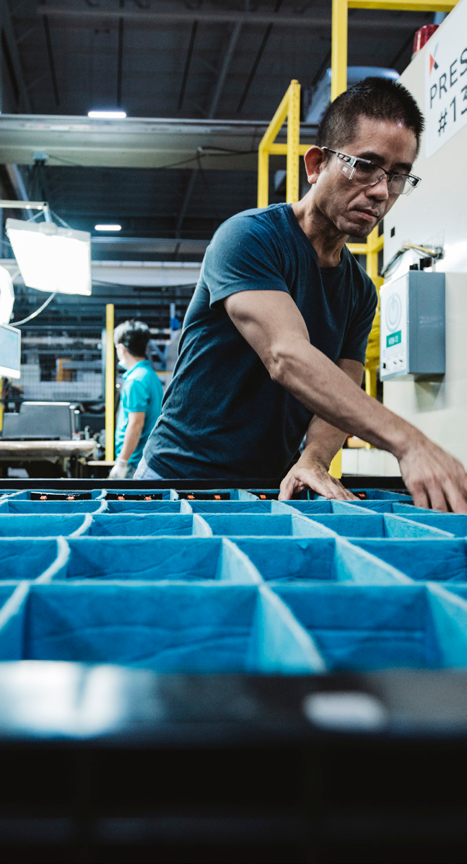 Worker operating production line in a brightly lit manufacturing facility