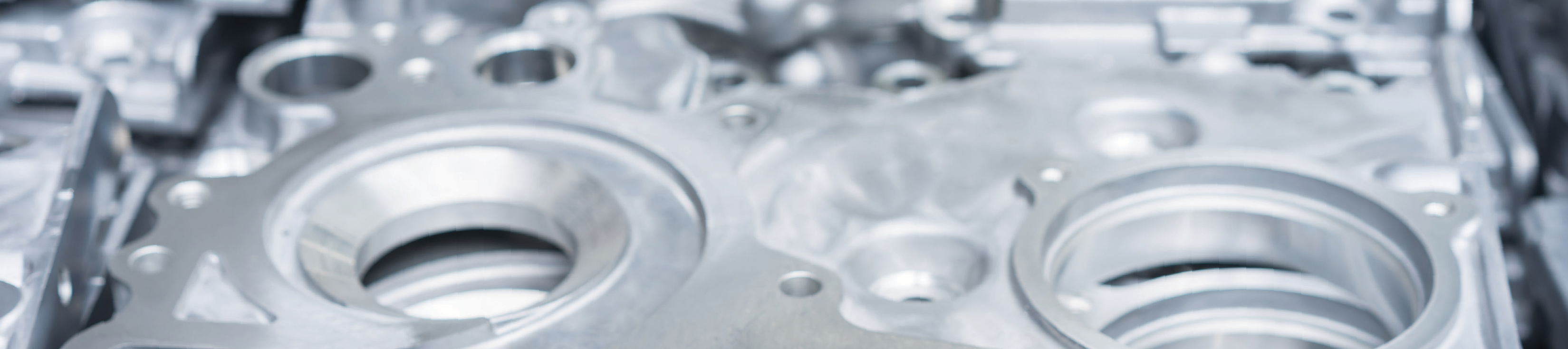 close-up photo of a mechanical component with circular openings and metallic surfaces