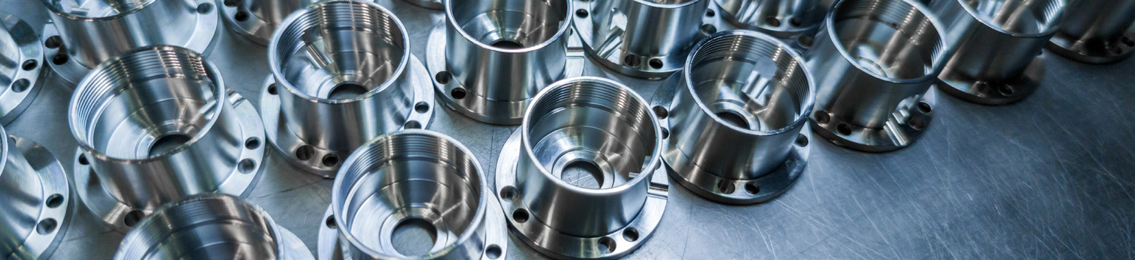 close-up photo of cast aluminum metal parts with threaded holes on a metallic surface