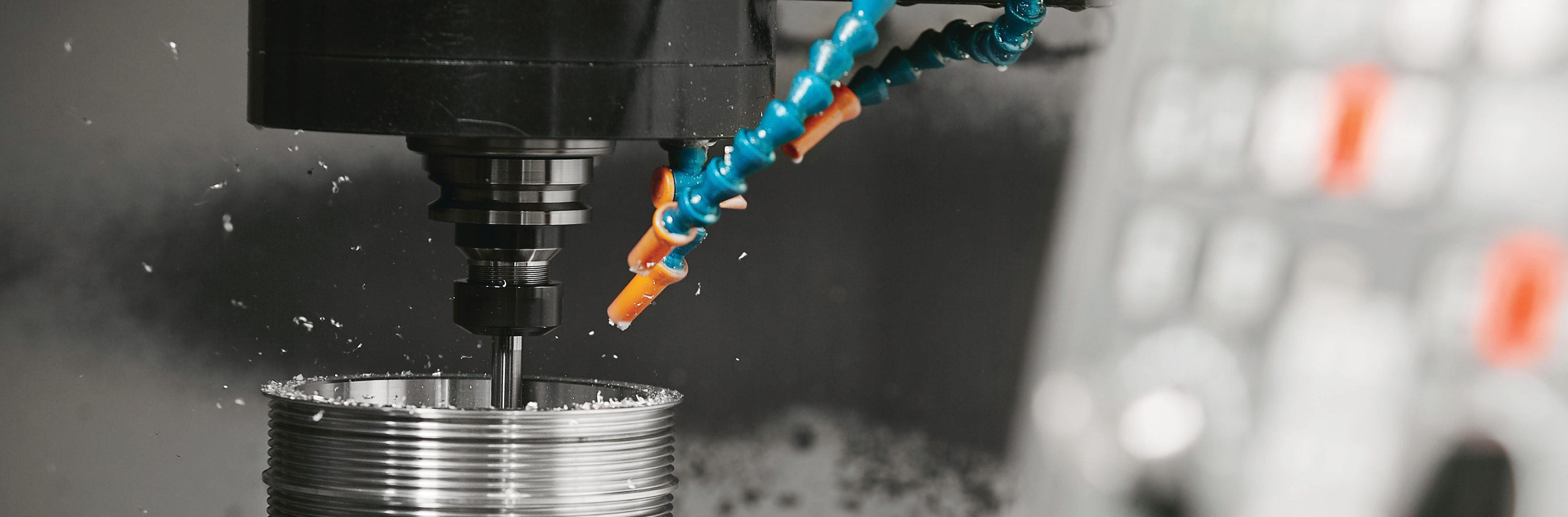 metalworking machine tool with coolant hoses in a manufacturing facility