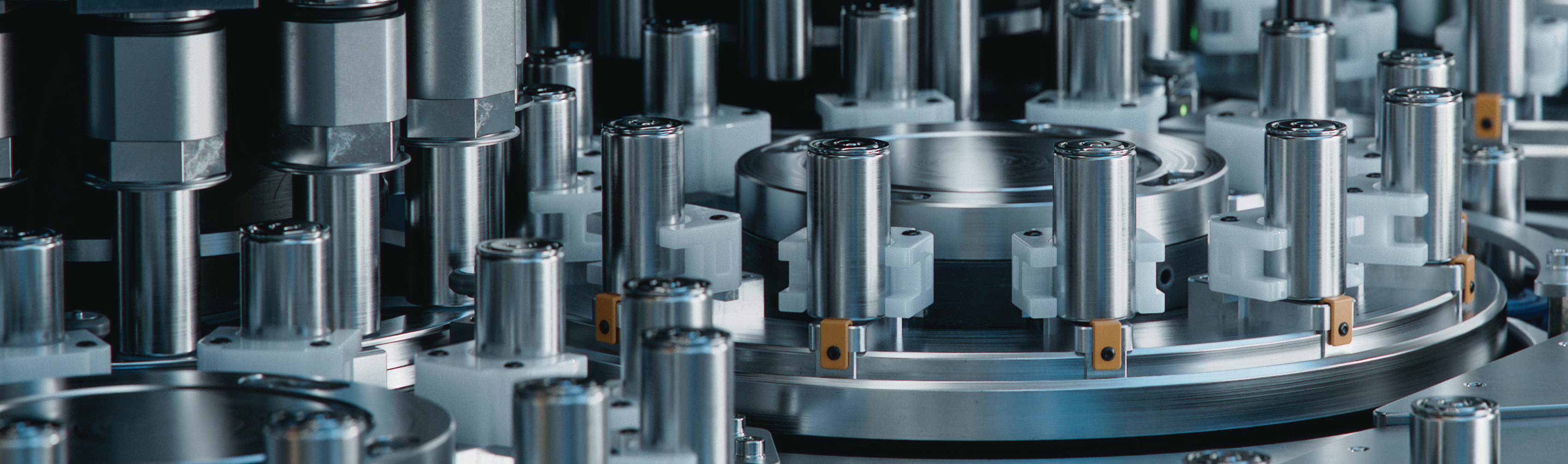 close-up photo of manufacturing equipment with multiple metal cylindrical components in a factory setting