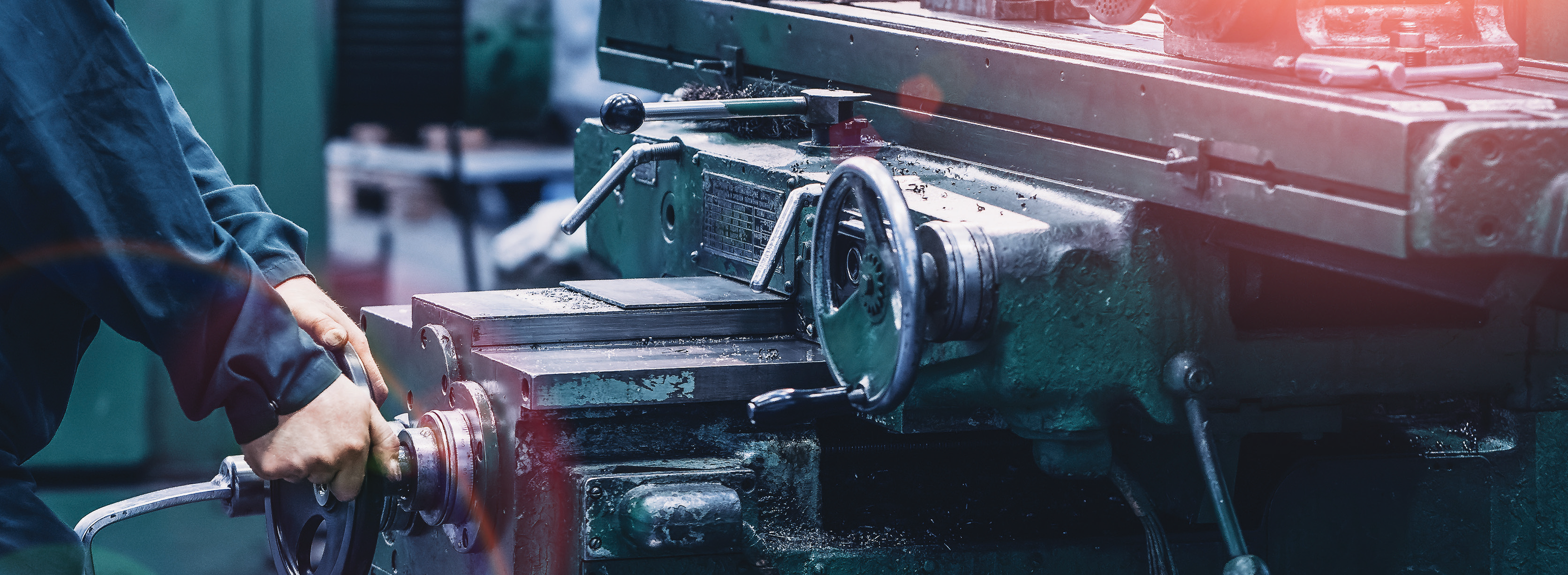operator working on a large industrial machine in a manufacturing facility