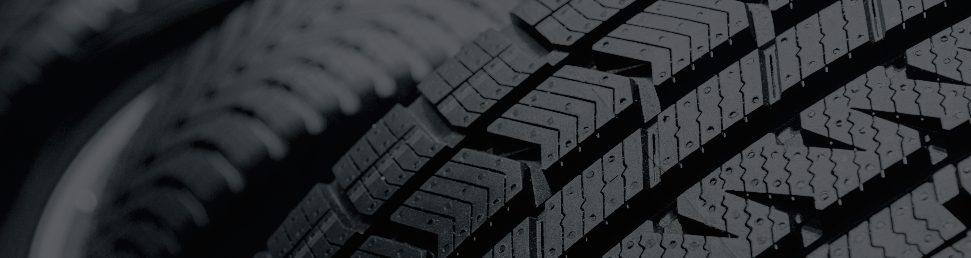 close-up photo of a tire tread pattern in black and gray tones