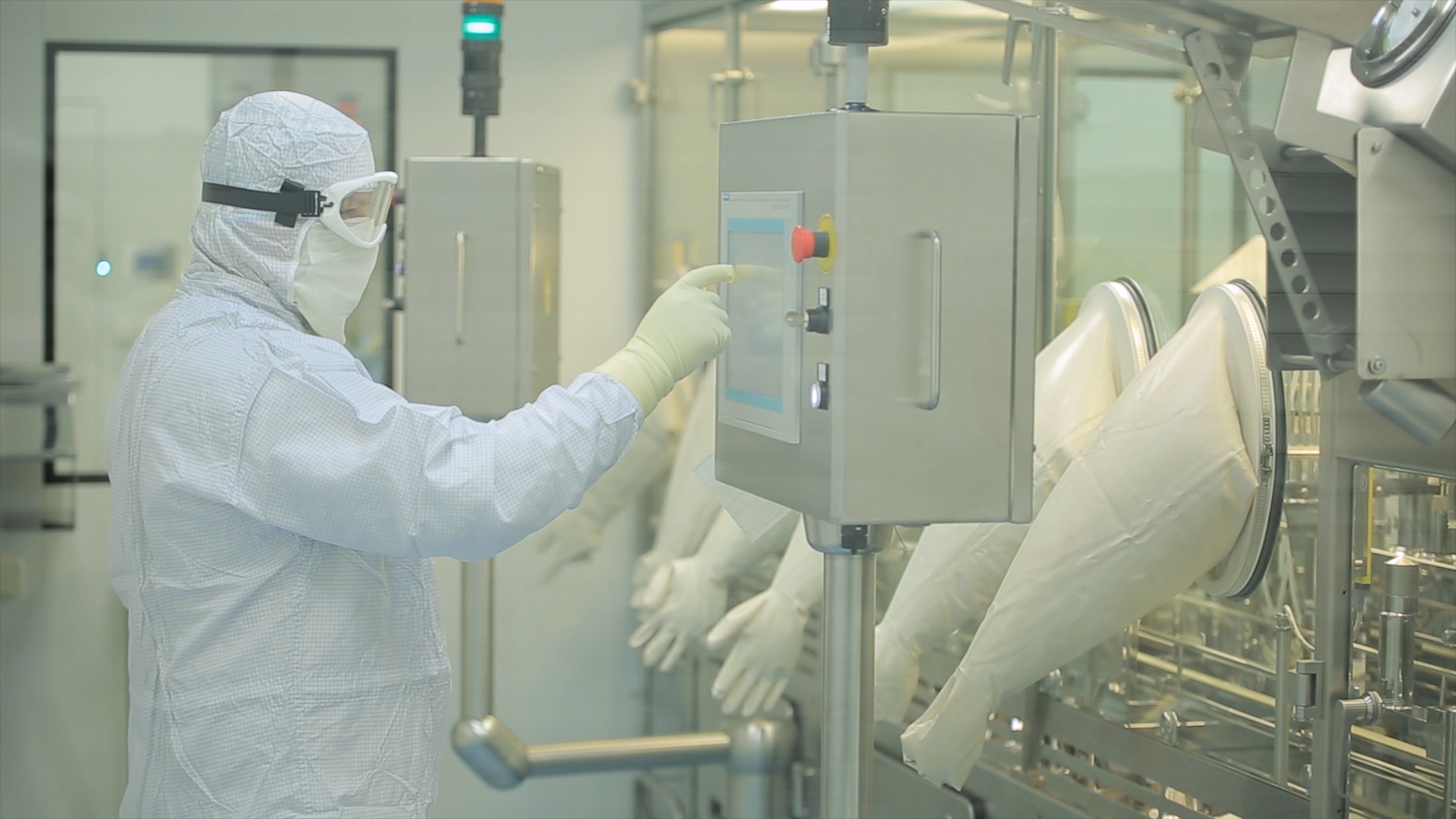 Pharmaceutical Production Line Worker at Work. Robotic arm lifting ampules at packaging line in pharmaceutical factory. Pharmaceutical industry. Ampule packaging machine