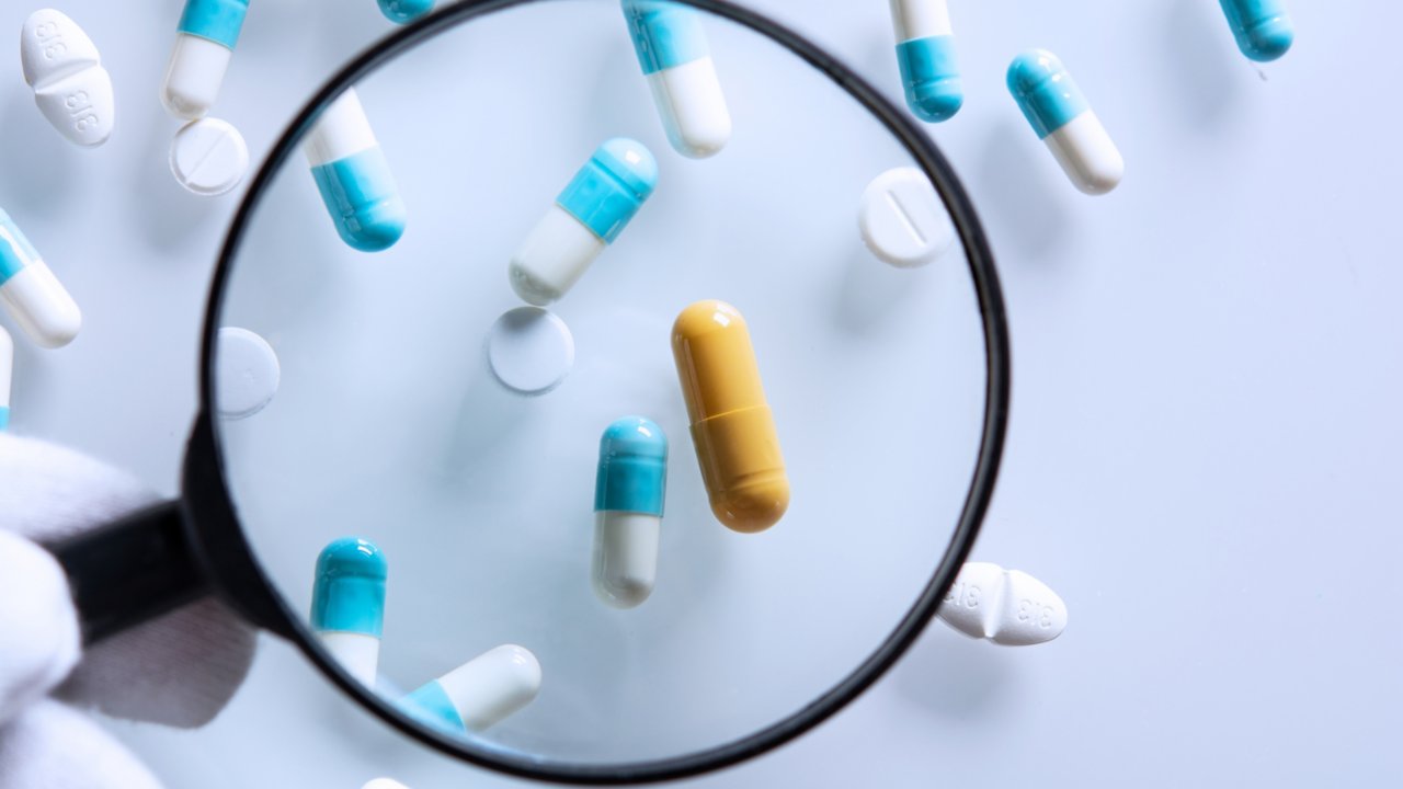 Pills in pharma under magnifying glass