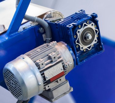 Electric motor with gear driven conveyor belt.A close-up image of a blue machine, emphasizing the motor and its engineering features in sharp detail.