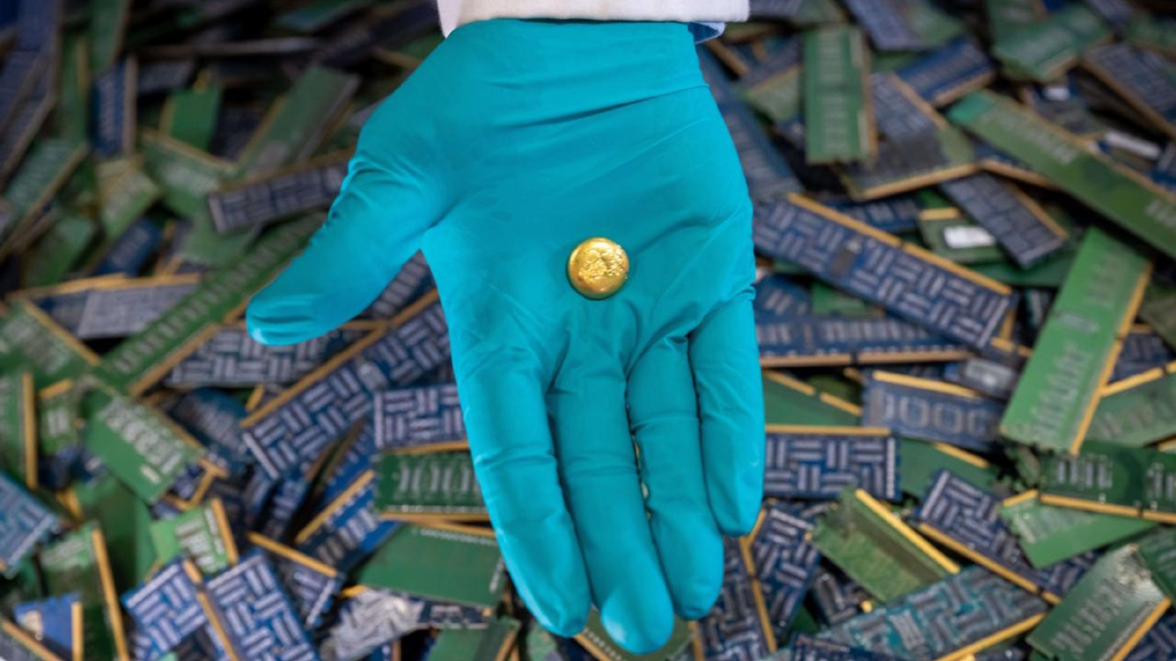 Gold pin placing in a hand in blue glove.