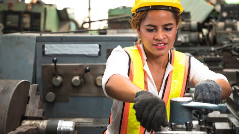 Safety industrial worker working and checking machine