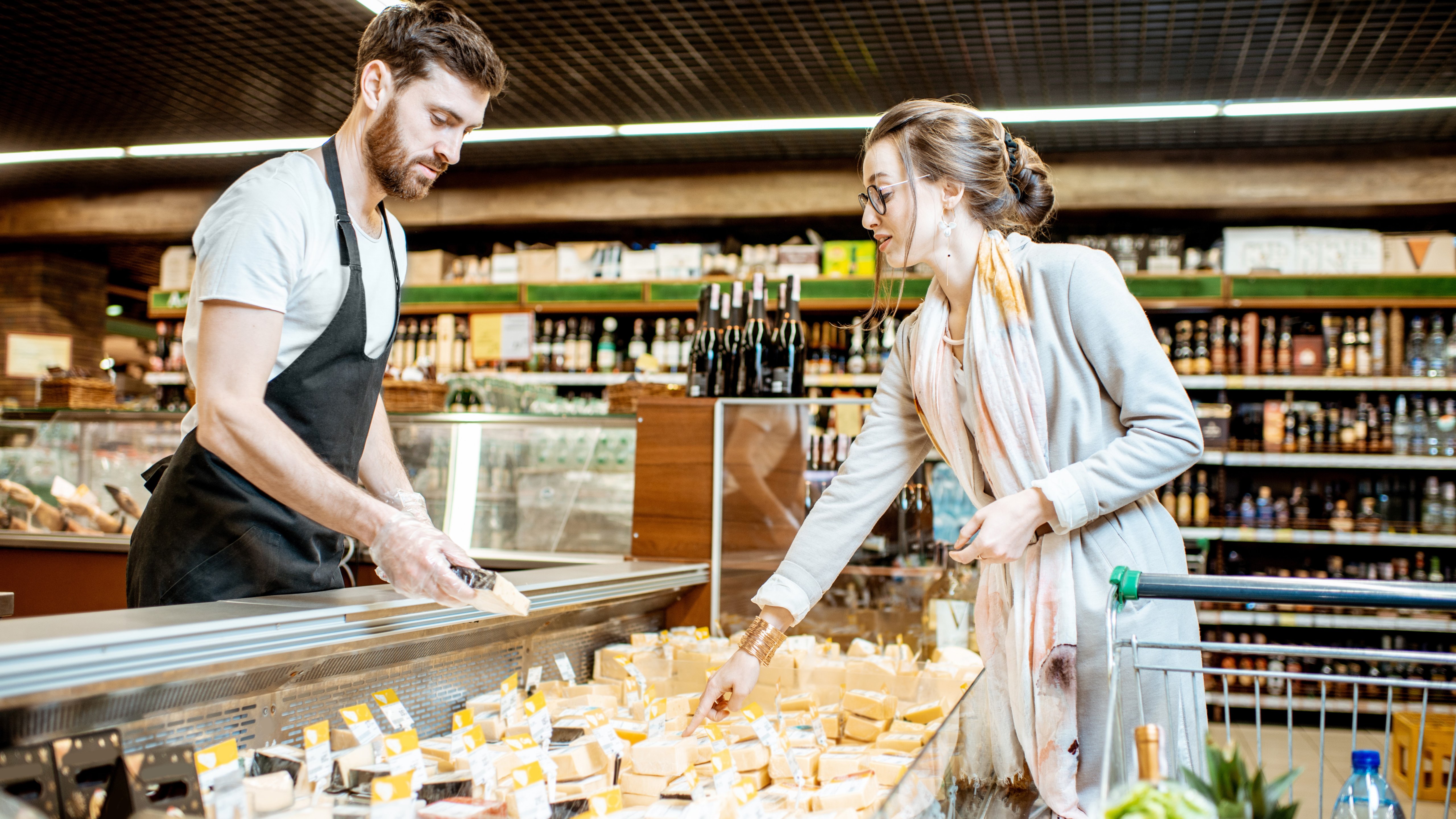 Cheese seller with woman client in the supermarket