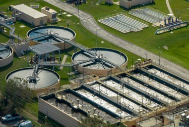 Aerial view of modern water cleaning facility at urban wastewater treatment plant. Purification process of removing undesirable chemicals, suspended solids and gases from contaminated liquid.