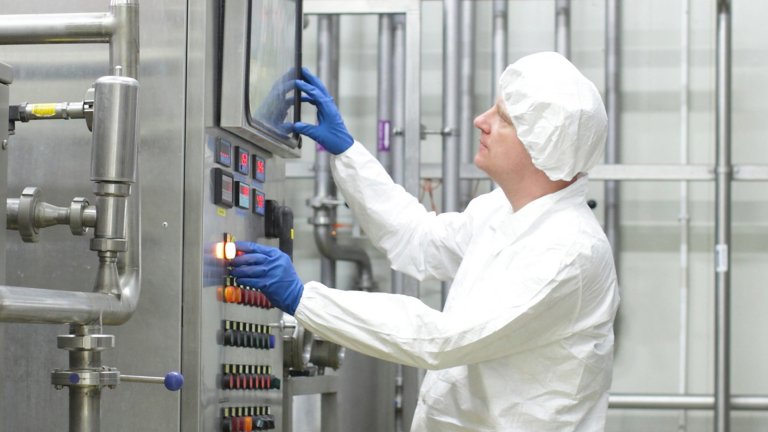 Technician inspects industrial equipment in factory